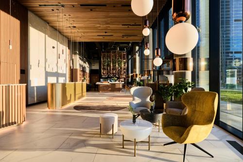 a lobby with chairs and tables in a building at Crowne Plaza - Warsaw - The HUB, an IHG Hotel in Warsaw