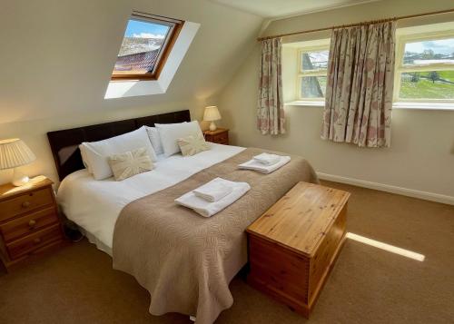 a bedroom with a large bed and two windows at Church House Farm in Danby