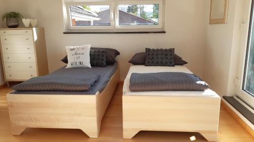 two twin beds in a room with a window at Attika Ferienwohnung Merk in Kreuzlingen