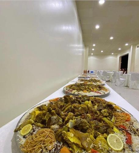 a row of plates of food on a table at Desert Rose Motel in Al Ghāţ
