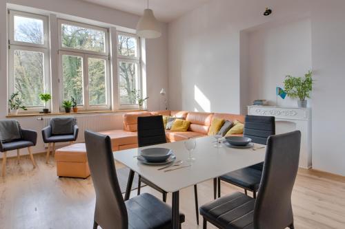 a living room with a table and chairs and a couch at Zamkowa Apart in Cieszyn