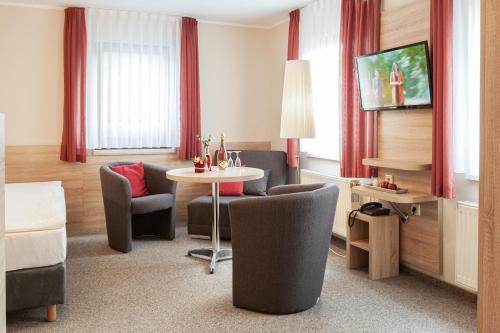 a hotel room with a table and chairs at Pension Hotel Sartor in Kurort Altenberg
