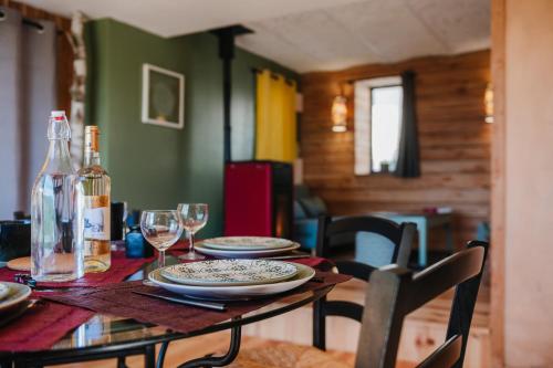 a dining room table with plates and wine glasses at La petite maison Basse Correo in Le Burety