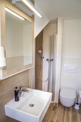 a bathroom with a white sink and a toilet at Pension Hotel Sartor in Kurort Altenberg