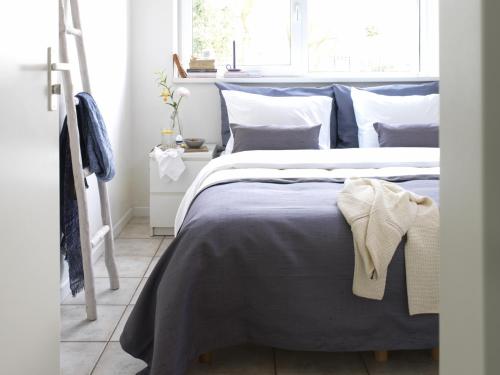 a bedroom with a bed with blue sheets and pillows at 12 persoons accommodatie in Loosdrecht