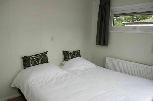 twee bedden naast elkaar in een slaapkamer bij 6 6 persoons Veluwe Villa met sauna en grillhuis in Voorthuizen
