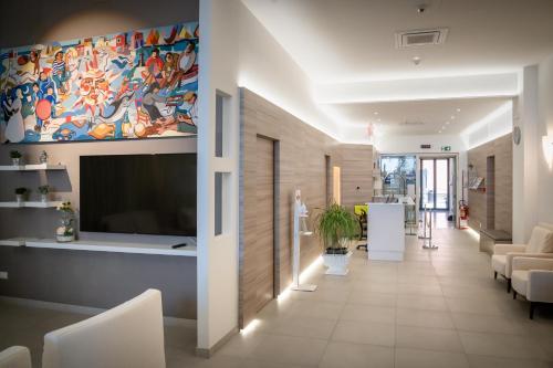 a living room with a large flat screen tv on a wall at Hotel Marco Polo in Caorle