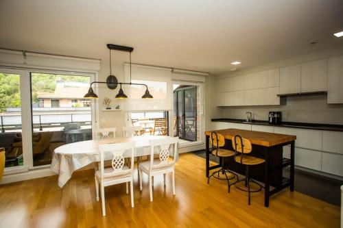 a kitchen with a table and chairs and a kitchen with a dining room at ÁTICO CONFORT ORIO Parking incluido in Orio