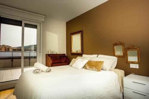1 dormitorio con 1 cama blanca grande y balcón en ÁTICO CONFORT ORIO Parking incluido, en Orio