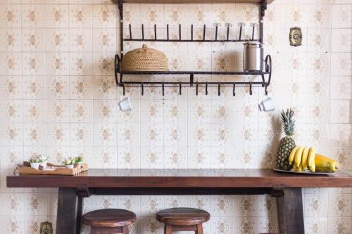 a kitchen with a wooden counter with stools at Pousada Rio Branco Nova Lima in Nova Lima