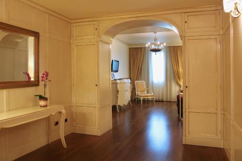 a room with a hallway with a table and a mirror at Villa Quaranta Tommasi Wine Hotel & SPA in Pescantina