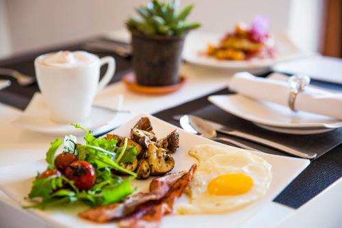 a plate of food with an egg and a salad at Cape Diem Lodge in Cape Town