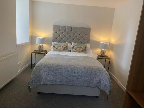 a bedroom with a large bed with two lamps at Holborn Apartment in Thurso