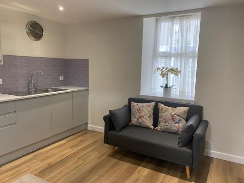 a living room with a couch and a kitchen at Holborn Apartment in Thurso