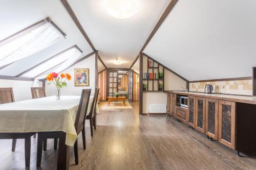 a dining room with a table and a kitchen at Hotel Pechory-Park in Pechory