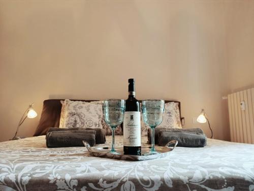 a bottle of wine and two glasses on a bed at Nido d'amore vista mare in Bordighera