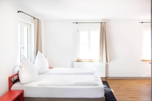 two beds in a white room with windows at KU Hotel by WMM Hotels in Kulmbach