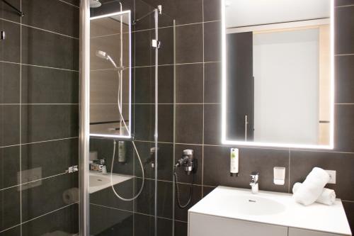a bathroom with a shower and a sink at KU Hotel by WMM Hotels in Kulmbach