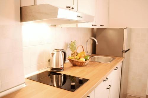 a kitchen with a sink and a bowl of fruit on a counter at Mljet Sunset Apartments in Pomena