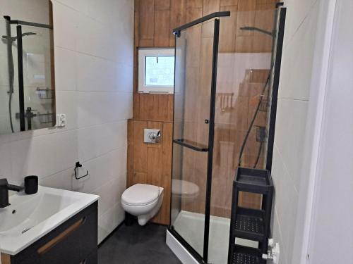a bathroom with a shower and a toilet and a sink at Radosna Zatoka - Domki mobilne i drewniane z ogródkami, apartamenty, namioty in Międzywodzie