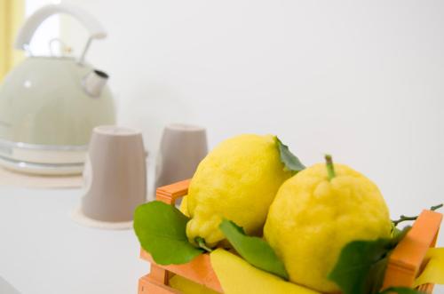 a pile of lemons in a wooden basket on a table at Maison San Paolo in Sorrento