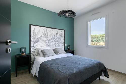 - une chambre avec un lit aux murs bleus et une fenêtre dans l'établissement Grain de Vie, à Saint-Gilles-Croix-de-Vie