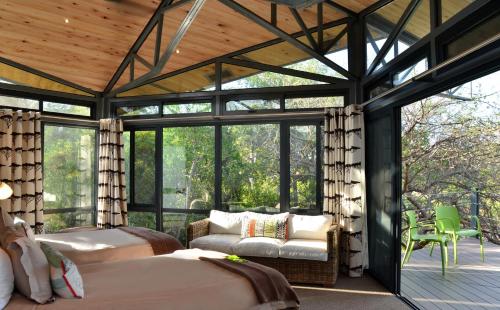 a bedroom with two beds in a room with windows at Greenfire Game Lodge in Balule Game Reserve