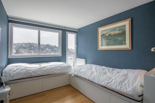 une chambre bleue avec un lit et une fenêtre dans l'établissement L'Observatoire, à Pléneuf-Val-André
