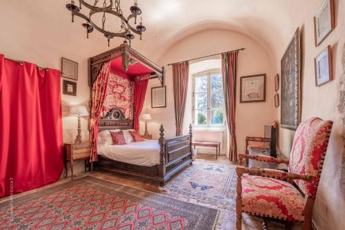 a bedroom with a canopy bed and red curtains at Château De Denonville in Denonville