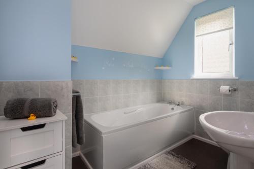 a bathroom with a white tub and a sink at Cornish Holiday - 100 Hengar Manor in Bodmin