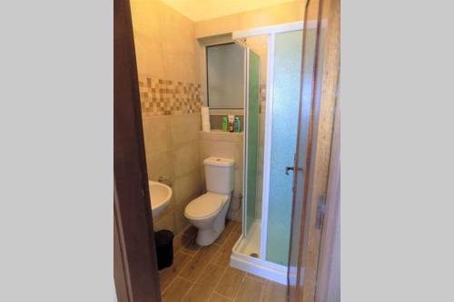 a bathroom with a toilet and a glass shower at Sunshine Holiday Apartment 5 with Spectacular Seaviews in St. Paul's Bay