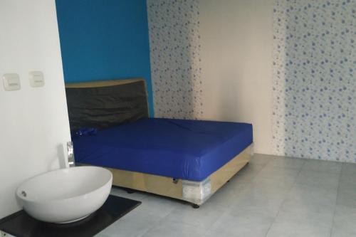 Habitación pequeña con cama y bol en el suelo en OYO 90439 Dkp 32, en Surabaya