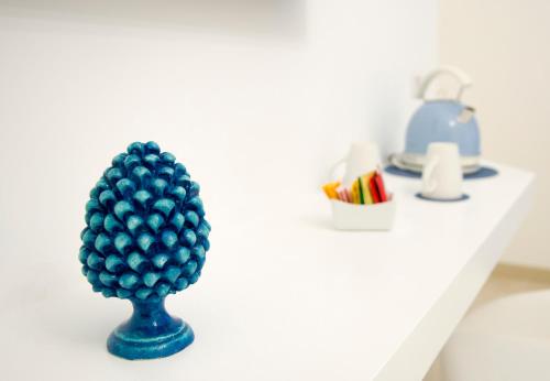 a blue pineapple vase on a white shelf at Maison San Paolo in Sorrento
