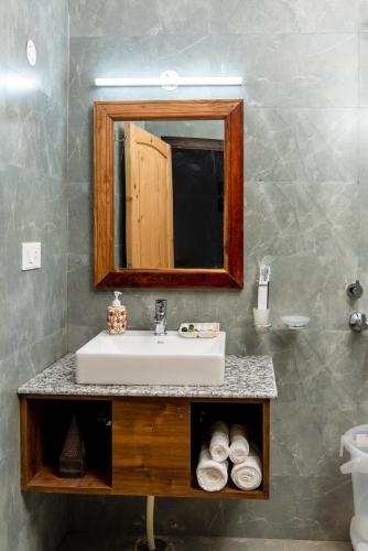 a bathroom with a sink and a mirror at ilaka Homes in Bīr