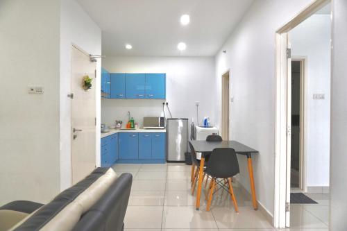 a kitchen with blue cabinets and a table and chairs at Gurney Drive Mansion One Serviced Apartment in George Town