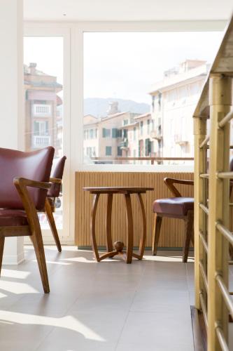 a table and chairs in a room with a window at Hotel Italia e Lido Rapallo in Rapallo