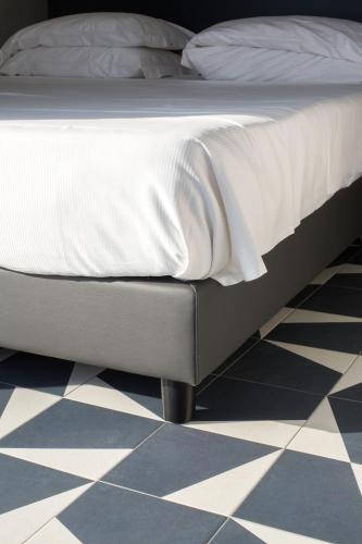 a bed in a bedroom with a checkered floor at Hotel Italia e Lido Rapallo in Rapallo