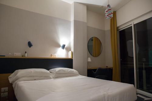 a bedroom with a white bed and a window at Hotel Italia e Lido Rapallo in Rapallo