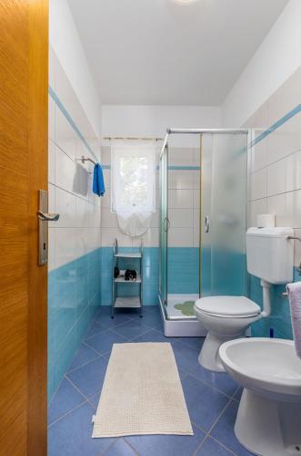 a bathroom with a shower and a toilet and a sink at Delightful villa with pool for 6 persons in Krmed