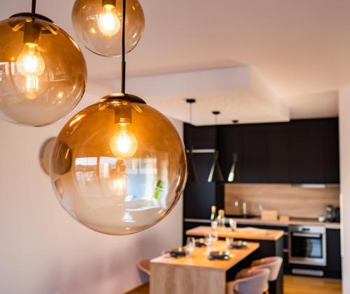 a kitchen with three lights hanging from the ceiling at Apartman Eden in Rožnov pod Radhoštěm