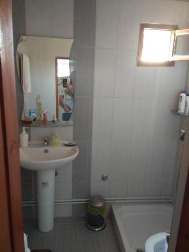 a bathroom with a sink and a mirror and a tub at Sofia's Cottage in Asprovalta