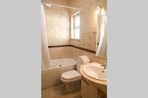 een badkamer met een bad, een toilet en een wastafel bij Vila G, Mira Luz in Luz