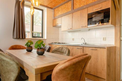 a kitchen with a wooden table and chairs at 8- person childbungalow - Theme Farm Adapted in Zuna