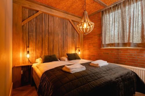 a bedroom with a large bed in a brick wall at 8- person childbungalow - Theme Farm Adapted in Zuna