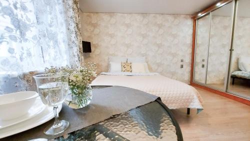 a bedroom with a bed and a table with glasses at "Снежность" на Коминтерна in Khanty-Mansiysk