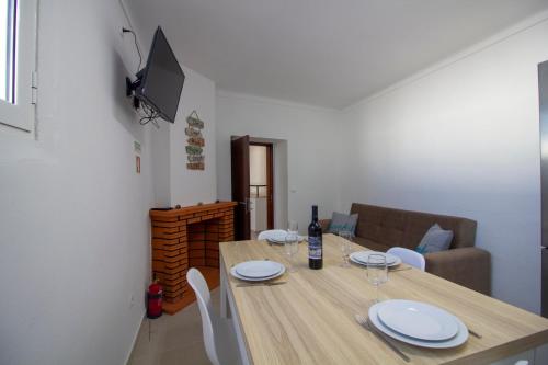 a dining room table with white plates and wine glasses at Recanto da Praça in São Pedro do Corval