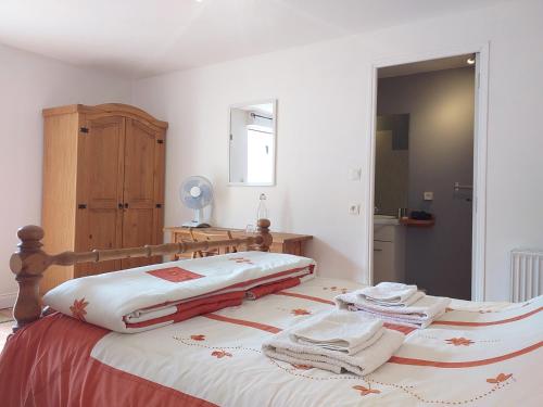 a bedroom with a bed with towels on it at Ancienne Ecole in Cazaux-Villecomtal