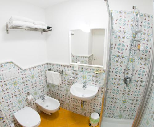 a bathroom with a sink and a toilet and a shower at Maison San Paolo in Sorrento