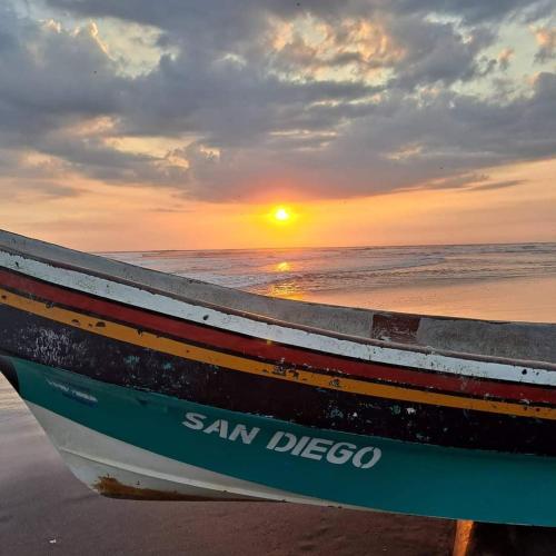 a boat sitting on the beach with the sunset at Casa Playa San Diego in San Diego
