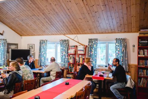 a group of people sitting at tables in a library at Alevi Camping in Stöllet